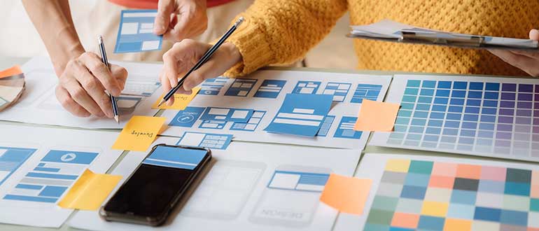 One woman is showing something on the table with a lot of labels to another person