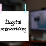 Digital marketing. Note is written on a white sticker that hangs with a clothespin on a rope on a background of office interior